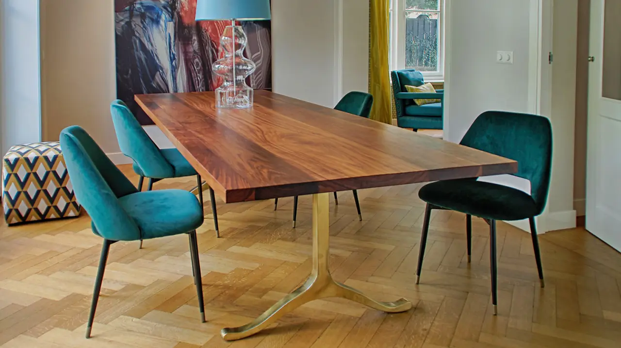Houten eettafel met petrolkleurige fluwelen stoelen op een visgraatvloer