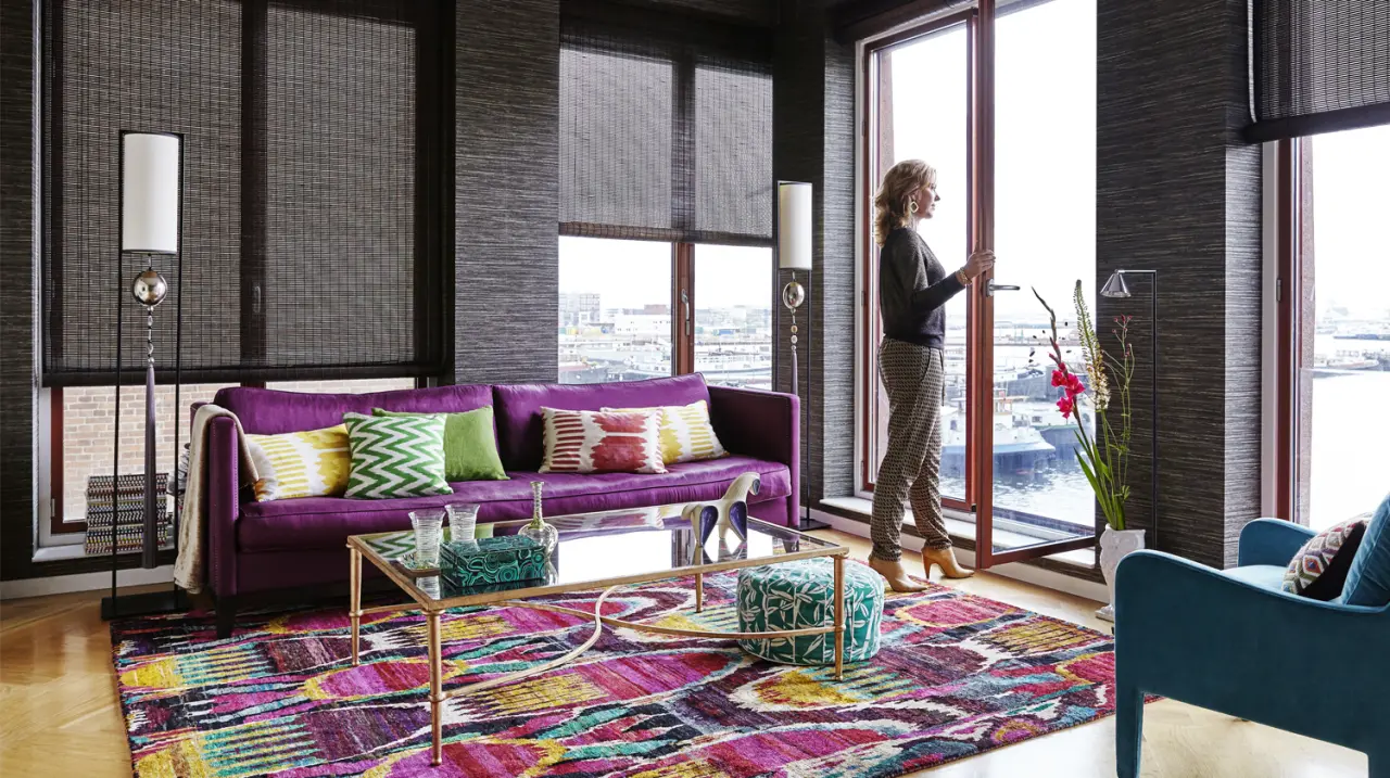 Woonkamer aan het water met paarse bank en een kleurrijk vloerkleed