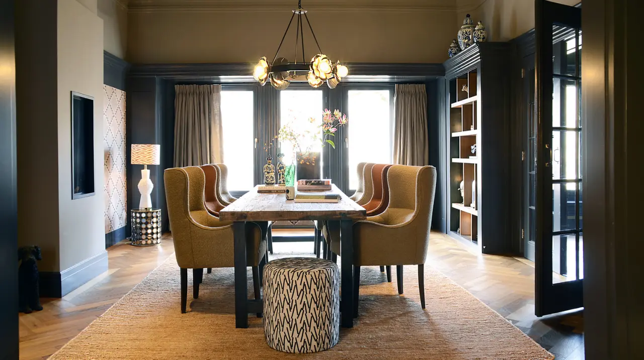 Eetkamer met houten tafel, okergele fauteuils en een ronde kroonluchter