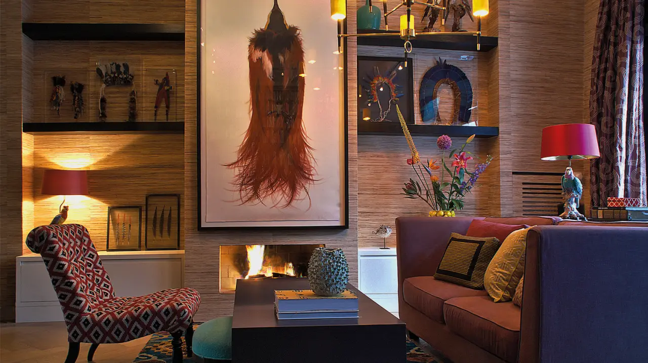 Zitkamer met open haard, kunst aan de wand en een paarse bank